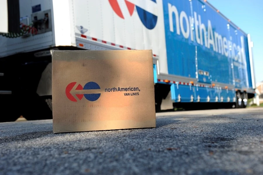 North American Van Lines cardboard box sitting on ground in front of truck